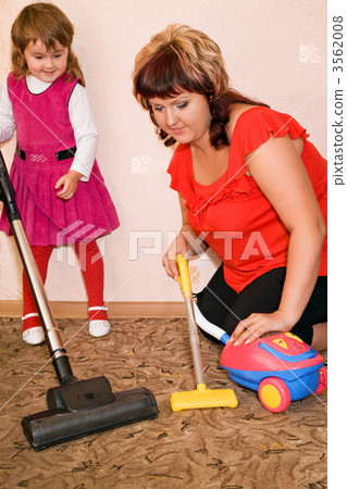 Little Girl and woman vacuum a carpet 3562008