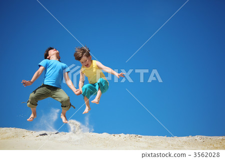 Two boys jump on sand Two boys jump on sand 3562028
