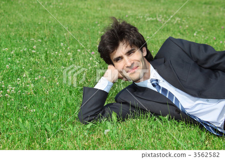 businessman has rest, lying on grass 3562582