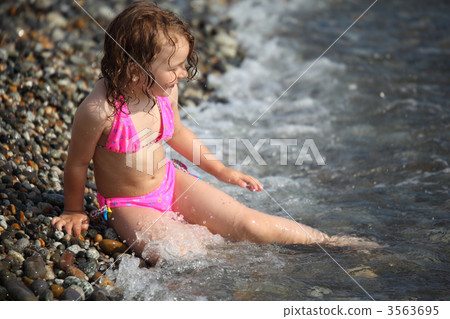 little girl sits ashore in waves little girl sits ashore in waves 3563695