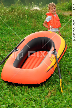 boy and inflatable boat on lawn 3563714