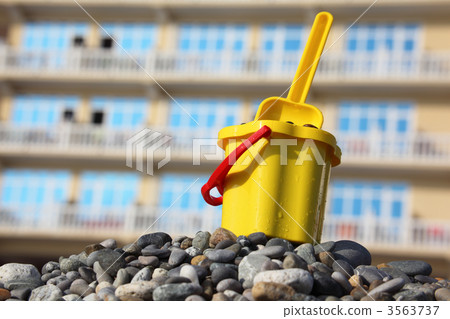Yellow children's bucket with scoop on pebble Yellow children's bucket with scoop on pebble 3563737