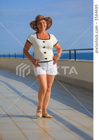 middleagede woman on balcony over sea full body middleagede woman on balcony over sea full body 3564695