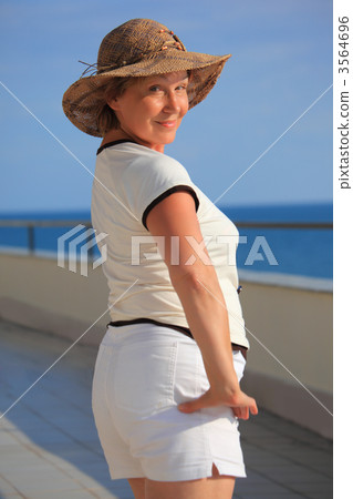 middleagede woman on balcony over sea middleagede woman on balcony over sea 3564696