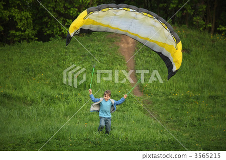 boy runs from hill with parachute 3565215