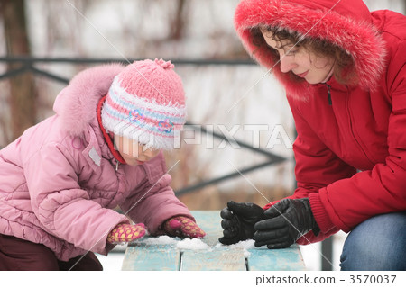 mother with child play with snow on bench mother with child play with snow on bench 3570037