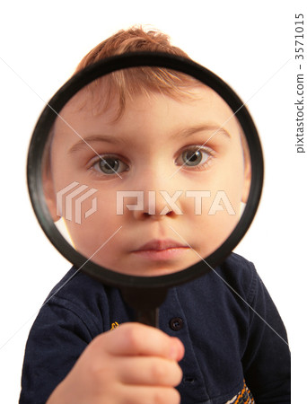 Child look through magnifier 3571015