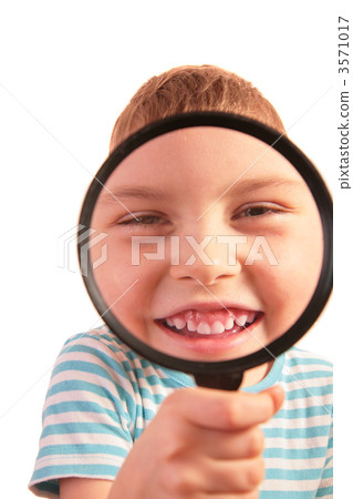 smiling child looks through magnifier 3571017