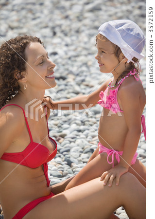 young beautiful woman with pretty little girl in white hat on st young beautiful woman with pretty little girl in white hat on st 3572159