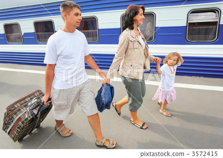 Happy family with little girl going on railway station 3572415