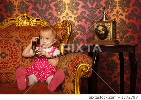 Little girl in red dress talking vintage phone. Interior in retr 3572797