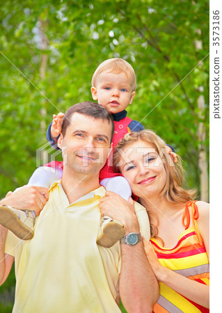 son sits on shoulders at father in park 3573186