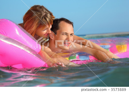 young man and nice women lying on an inflatable mattress in pool young man and nice women lying on an inflatable mattress in pool 3573889
