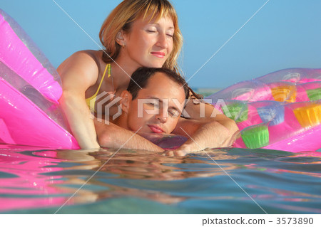 young man and nice women sleep on an Inflatable mattress in pool young man and nice women sleep on an Inflatable mattress in pool 3573890