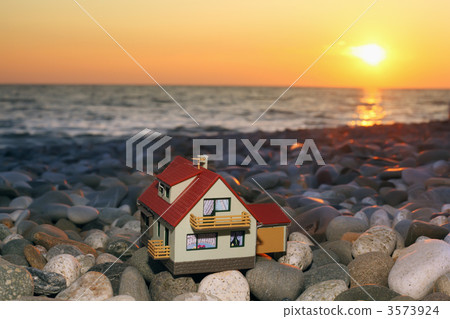 model of house with garage on stony beach in evening 3573924