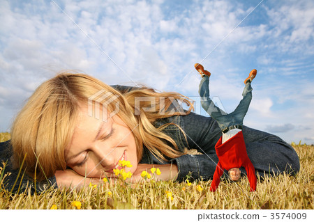young woman lies on the grass and miniature boy on hands collage young woman lies on the grass and miniature boy on hands collage 3574009