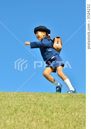 A kindergarten child (a girl) running on the lawn A kindergarten child (a girl) running on the lawn 3584252
