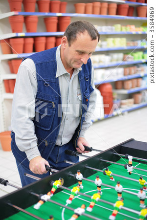 Man plays into table football in store 3584969