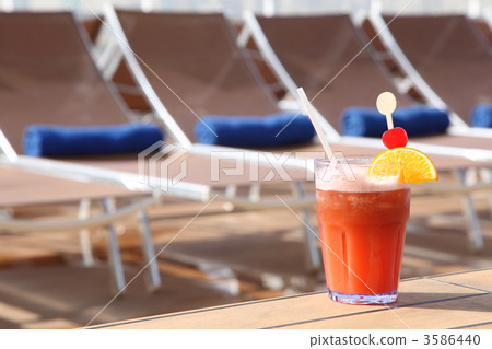cocktail with fruits in glass on rail near beach armchair in cru cocktail with fruits in glass on rail near beach armchair in cru 3586440