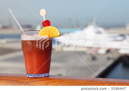 cocktail with fruits in glass on ship deck rail, port with cruis cocktail with fruits in glass on ship deck rail, port with cruis 3586447