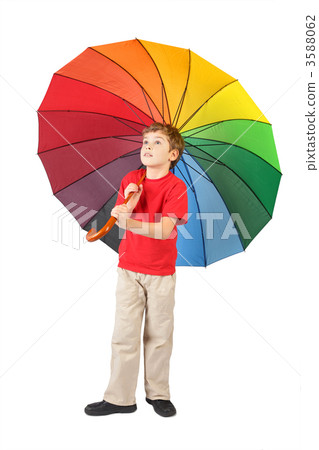 boy in red shirt with big multicolored umbrella standing on whit 3588062
