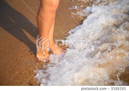 Legs in wave on sand 3588191