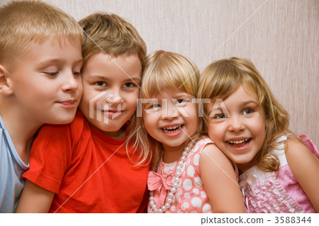 Laughing children four together in cosy room, two pretty girls a Laughing children four together in cosy room, two pretty girls a 3588344