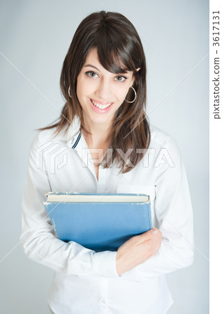 Smiling brunette in white shirt holding a book 3617131