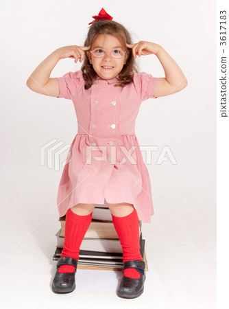 Bespectacled little girl with a with her fingers on her forehead Bespectacled little girl with a with her fingers on her forehead 3617183