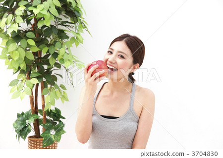 A girl grazing at an apple 3704830
