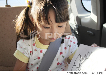 3 year old child reading a book with a seat belt 3734391