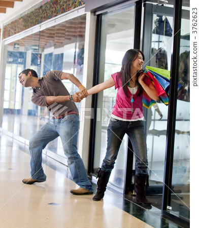Man keeping a woman from entering a store 3762623