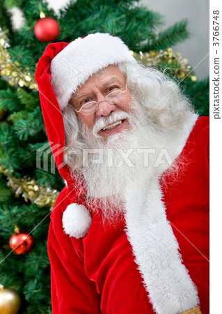 Santa next to a christmas tree 3766748