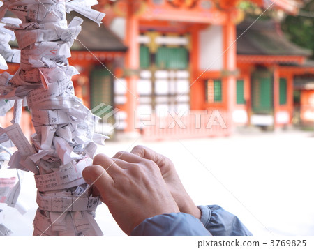 A hand of a woman tying an Omikuji A hand of a woman tying an Omikuji 3769825