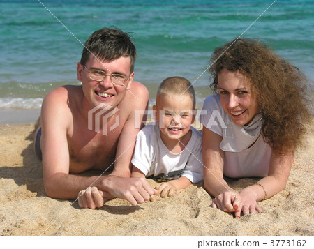 family lies on beach 2 3773162
