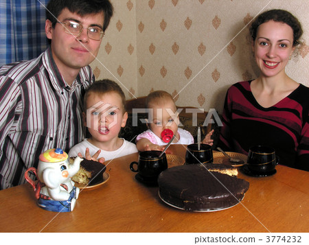 Family of four behind a kitchen table Family of four behind a kitchen table 3774232