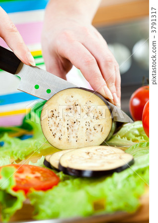 Woman's hands cutting aubergine eggplant 3791317