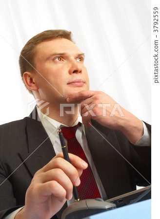The businessman in a suit behind a table. The businessman in a suit behind a table. 3792559