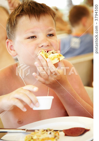 boy eats a pizza in summer cafe on a beach 3794500