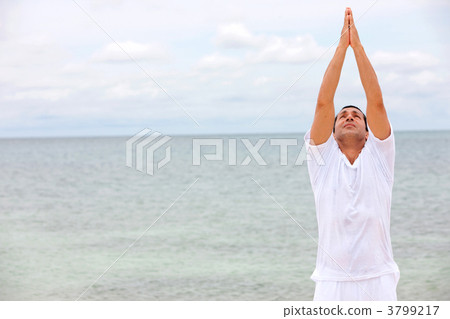Man at the bach doing yoga 3799217