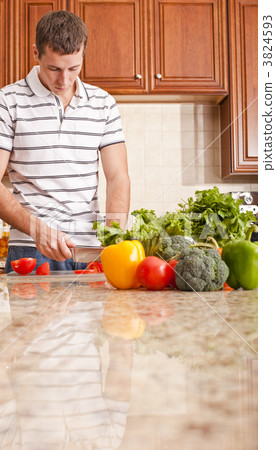 Young Man Cutting Tomato Young Man Cutting Tomato 3824593