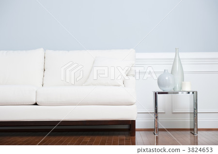 White Sofa and Glass End Table Against Blue Wall White Sofa and Glass End Table Against Blue Wall 3824653
