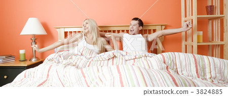 Young Couple Lying in Bed Stretching 3824885