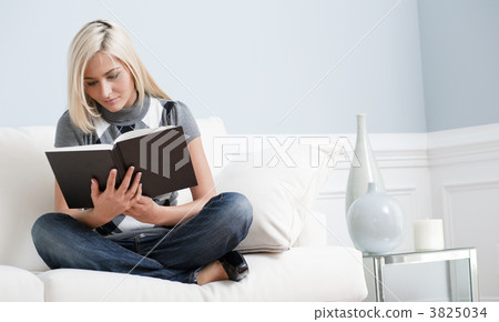 Woman Sitting on Couch and Reading a Book 3825034