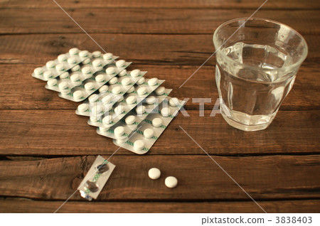 A sheet of white pills and drinking water, 2 pills per dose 3838403