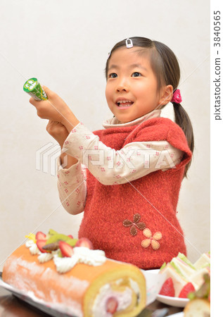 A girl ringing a cracker at a party A girl ringing a cracker at a party 3840565