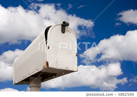 Weathered Old Mailbox Against Blue Sky and Clouds Weathered Old Mailbox Against Blue Sky and Clouds 3862589