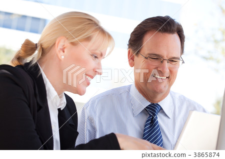 Businessman and Female Colleague Using Loptop Outdoors Businessman and Female Colleague Using Loptop Outdoors 3865874