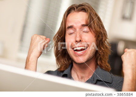 Cheering Young Man Using Laptop Computer Cheering Young Man Using Laptop Computer 3865884