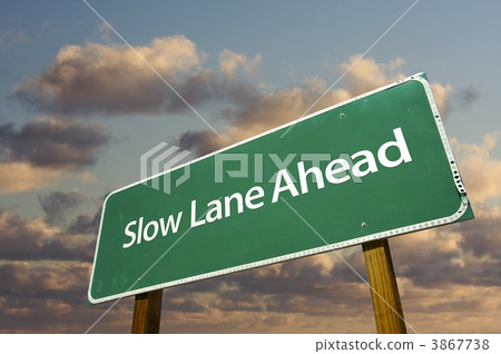 Slow Lane Ahead Green Road Sign Over Clouds Slow Lane Ahead Green Road Sign Over Clouds 3867738